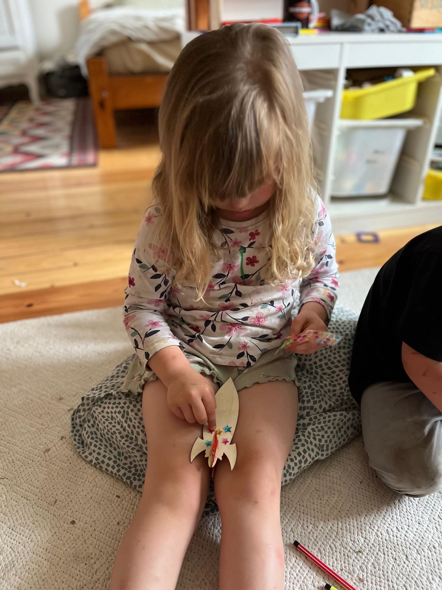 Bērns aplīmē koka kosmosa kuģi